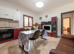 una cucina con tavolo e sedie in una cucina di Villa Giulietta a Castiadas Altre 16 foto