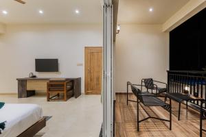 een slaapkamer met een bed en een bureau met een televisie bij Samarya Chikkamagaluru in Chikmagalūr