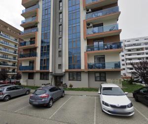 two cars parked in a parking lot in front of a building at Modern Stay in Şelimbăr +2 photos