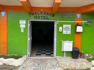 a hotel entrance with a green and orange building at Chaleanor Hotel in Dangriga