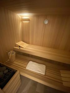 eine kleine Holzsauna mit weißem Handtuch in der Unterkunft La Villa Mellifera in Cernay-lès-Reims