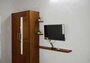 een flatscreen-tv die bovenop een muur staat bij MeadowView Cottage Marari in Mararikulam