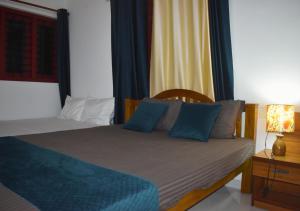 een slaapkamer met een bed met blauwe kussens bij MeadowView Cottage Marari in Mararikulam +22 foto's