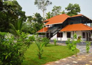 een huis met een oranje dak en een tuin bij MeadowView Cottage Marari in Mararikulam