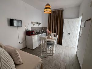 Habitación con cocina y mesa con sillas. en Casa Patio Paraíso, en Vejer de la Frontera