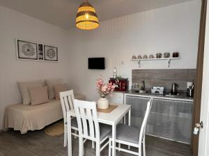 Una sala de estar con mesa y sillas y una cocina. en Casa Patio Paraíso, en Vejer de la Frontera