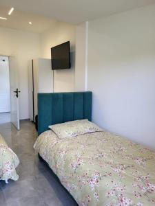 a bedroom with a bed with a blue head board at Hotel Liqeni in Elbasan