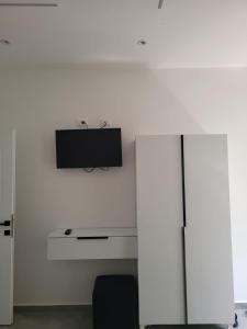 a room with a tv on a white wall at Hotel Liqeni in Elbasan