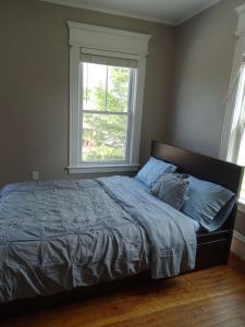 een bed in een slaapkamer met een groot raam bij Spacious Home in Framingham MA in Framingham