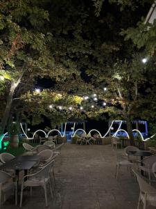 a patio with tables and chairs at night at Hotel Liqeni in Elbasan +12 photos