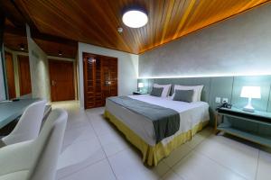 ein Schlafzimmer mit einem Bett, einem Tisch und Stühlen in der Unterkunft Hotel Águas Claras in Santa Cruz do Sul + 33 Fotos