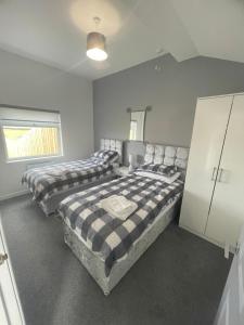 a bedroom with two beds and a cabinet at 1 Lighthouse View in Lossiemouth