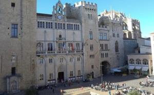 ein großes Steingebäude mit einem Uhrenturm darauf in der Unterkunft Thomas Price Appart in Narbonne