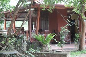 een huis met een veranda met stoelen en bomen bij Wilpattu Haritha Villa in Pahala Maragahawewa