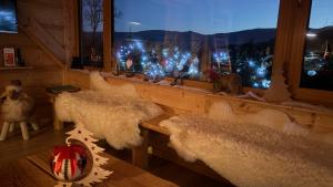 a room with a window with white furry seats and christmas lights at Apartament Hakerówka in Szklarska Poręba