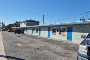 a building with blue and white doors on a street at Base Motel By OYO South Tampa in Tampa