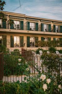 a building with a fence and chairs in a garden at Auberge du Rédier - Logis Hôtels in Colomars
