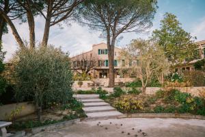 een gebouw met bomen en trappen in een tuin bij Auberge du Rédier - Logis Hôtels in Colomars