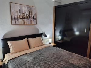 een slaapkamer met een bed en een schilderij aan de muur bij Vasiliki's apartment in Serres