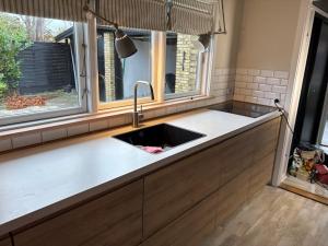 un bancone della cucina con lavandino e due finestre di Villa Svane a Rødby Altre 29 foto