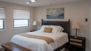 a bedroom with a large bed and two windows at Penthouse Beachfront Views Renovated condo in South Padre Island