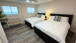 two beds in a room with two windows at Penthouse Beachfront Views Renovated condo in South Padre Island +125 photos