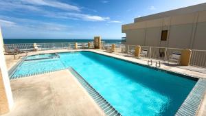 a swimming pool with the ocean in the background at Penthouse Beachfront Views Renovated condo in South Padre Island