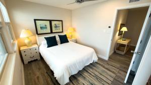 a bedroom with a white bed with blue pillows at Penthouse Beachfront Views Renovated condo in South Padre Island
