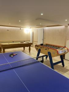 ein Raum mit zwei Tischtennisplatten und einem Billardtisch in der Unterkunft La Villa Mellifera in Cernay-lès-Reims + 18 Fotos