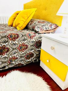 un letto con un cuscino giallo e un comò bianco di Tineo centro a Tineo Altre 9 foto