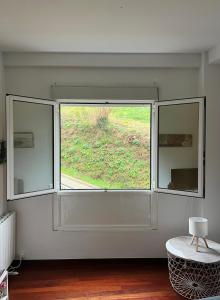 una grande finestra in una stanza con tavolo di Tineo centro a Tineo