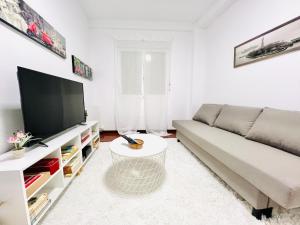 a living room with a couch and a flat screen tv at Tineo centro in Tineo