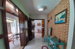 una stanza con un corridoio con un muro di mattoni e una porta di Casa em Peruíbe com piscina a Peruíbe