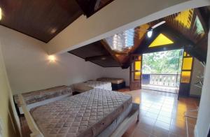 una camera da letto con un letto e una grande finestra di Casa em Peruíbe com piscina a Peruíbe Altre 13 foto