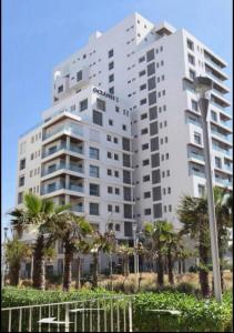 卡萨布兰卡Panorama sur l'infini的一座巨大的白色建筑，前面有棕榈树