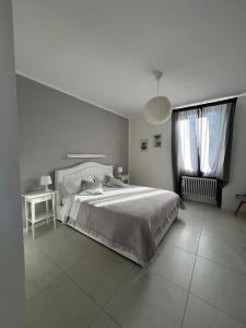 a bedroom with a bed and a table and two windows at Il Rifugio in Sulmona