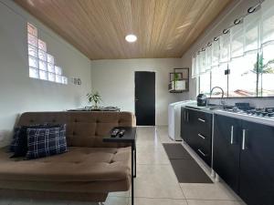 a living room with a couch and a kitchen at Studio Aconchegante - com Garagem Privativa e Ar Condicionado REV391 in Joinville