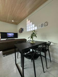 a dining room with a black table and chairs at Studio Aconchegante - com Garagem Privativa e Ar Condicionado REV391 in Joinville