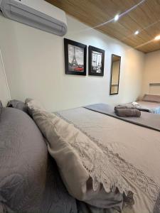 a bedroom with two beds and two pictures on the wall at Studio Aconchegante - com Garagem Privativa e Ar Condicionado REV391 in Joinville