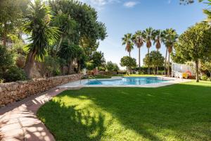 una piscina in un cortile con palme di Mijas la Nueva a Mijas