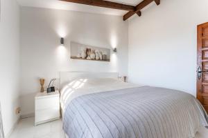 una camera bianca con un letto con una coperta blu di Mijas la Nueva a Mijas Altre 26 foto