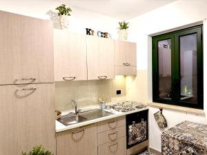 a kitchen with a sink and a window at Pine Beach House - Villaggio Turistico con Piscina e Animazione in Campofelice di Roccella