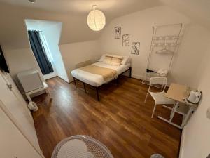une chambre avec un lit, une table et des chaises dans l'établissement 43 Deluxe London Ensuites, à Londres