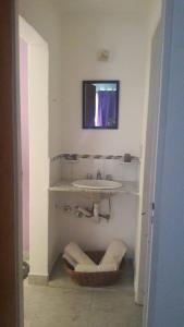 a white bathroom with a sink and a mirror at Anisados 1 in Las Grutas