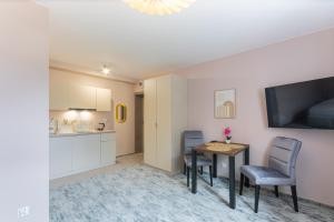ein Wohnzimmer mit Tisch und Stühlen und eine Küche in der Unterkunft Apartamenty Sarnia 6A in Karpacz