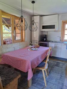 una cucina con tavolo e tovaglia rosa di Tiroler Knusperhäuschen a Tannheim