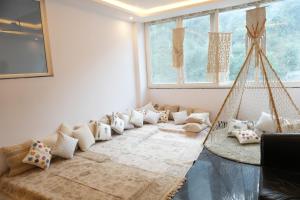 a living room with a bunch of pillows on a couch at Sufi Stay in Rishīkesh