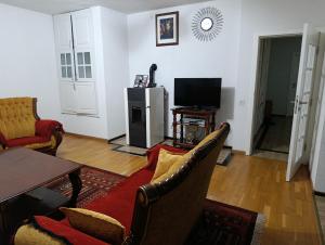 a living room with a couch and a tv at Besi Vushtrri in Mitrovicë