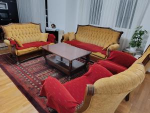 a living room with two couches and a coffee table at Besi Vushtrri in Mitrovicë