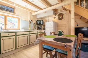 a kitchen with a table with chairs and a refrigerator at Les inséparables in Saint-Pierre-de-Curtille